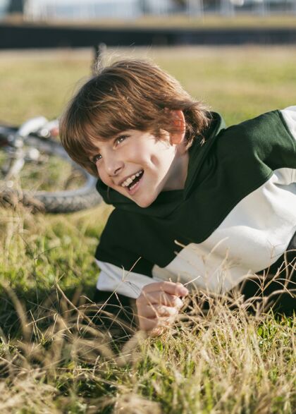 孩子骑着自行车在草地上放松的快乐男孩户外自行车活跃