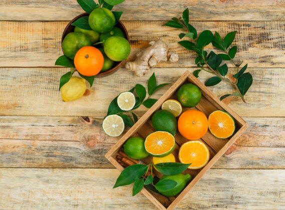 部分顶视图柑橘类水果在一个木碗和板条箱与树叶和生姜葡萄柚食物素食