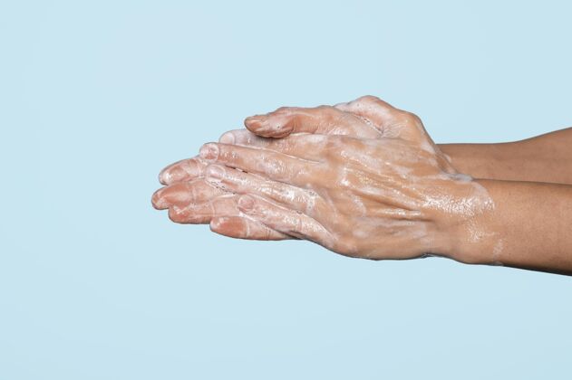 手在蓝色上洗手的女人清洁预防健康
