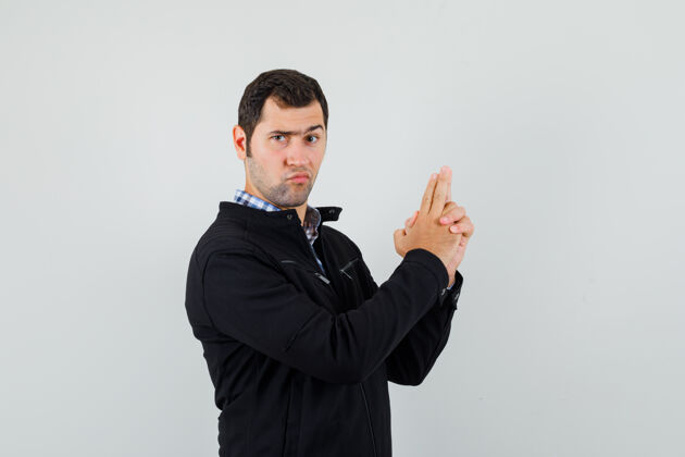 成功年轻人做手指标志在衬衫 夹克和看起来自信休闲手指胡须
