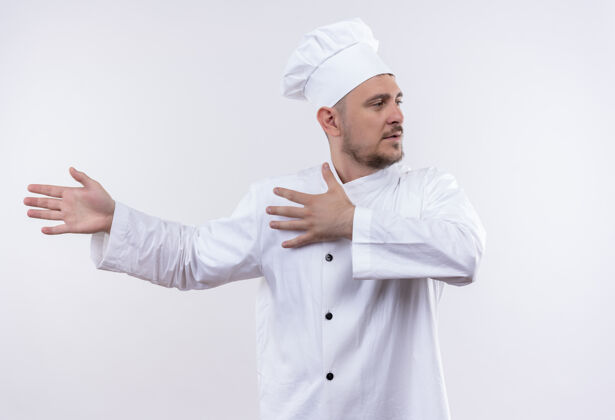 指着年轻帅气的厨师身着厨师制服 双手指着左边 看着旁边的空白处手看着厨师