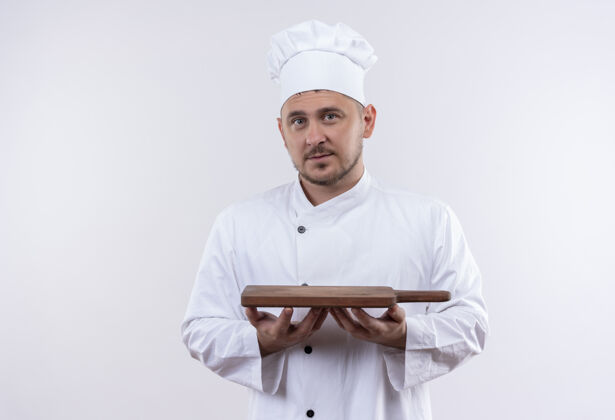 年轻年轻帅气的厨师穿着厨师制服 拿着砧板 在白色的空间里显得孤立无援期待持有烹饪