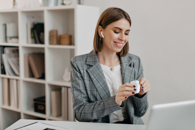 自信身着办公装的微笑女人戴上飞碟与顾客交流的画像成功灰色夹克经理