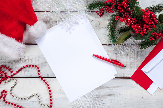 乡村在木桌上放一张白纸 上面有钢笔和圣诞装饰品玩具写作礼物