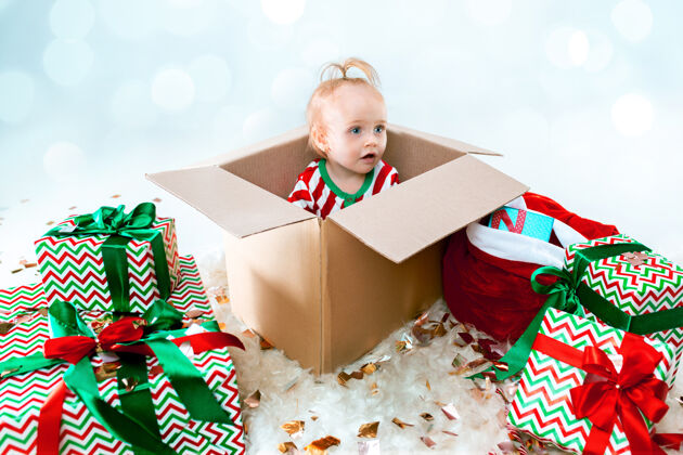 灯可爱的女婴1岁坐在盒子里过圣诞节礼物玩舞会