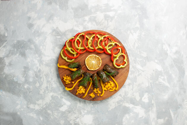 盖顶视图切碎的甜椒和叶子放在白色的桌子上肉蔬菜陶瓷