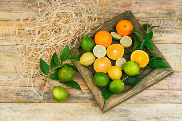 部分一些柑橘类水果放在铜板上的木板上美味一半叶子