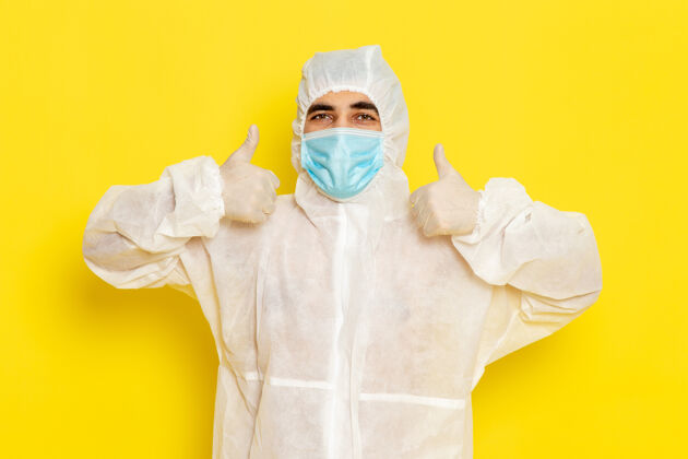 工人身穿白色特殊防护服 戴着黄色面具 面带微笑的男科学工作者的正面图医疗防护实验室