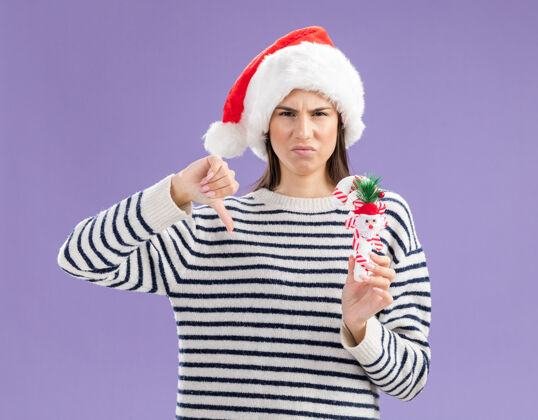 圣诞戴着圣诞帽的未出嫁的白人少女手持糖果手杖 大拇指朝下拇指新复制
