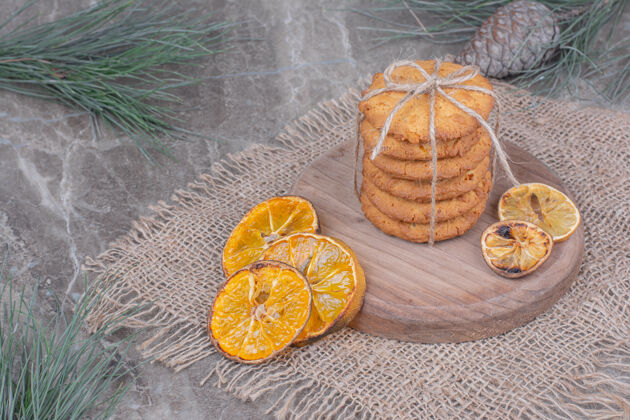 美味放在木板上的饼干 周围是橘子片风味美味酥脆