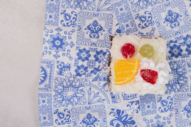 美味把一片白蛋糕和水果片放在桌布上切片蛋糕奶油
