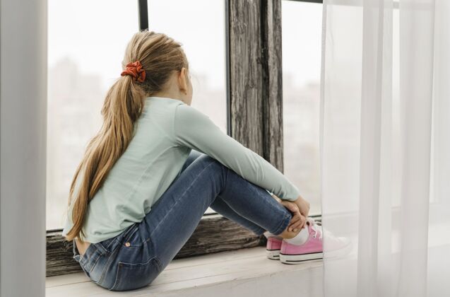 呆在家里侧视图坐在窗台上的小女孩病毒护理呆在家里