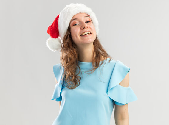 自信身穿蓝色上衣 头戴圣诞帽的年轻女子 看上去幸福快乐 微笑自信微笑快乐年轻