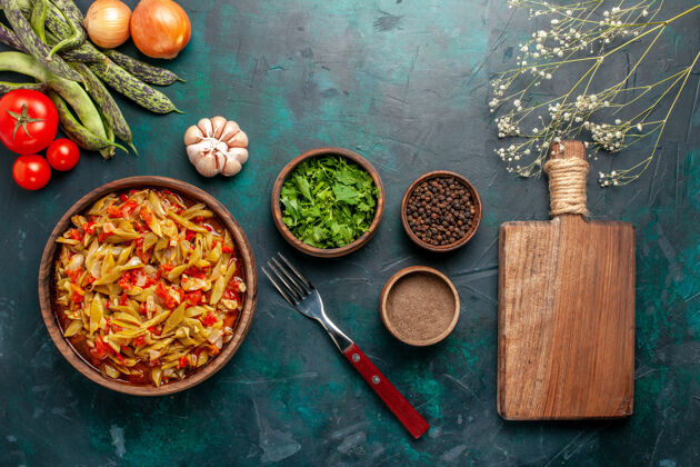 晚餐在深蓝色背景上 用不同的配料和调味料制作的蔬菜切片 俯视图胡椒粉烹饪蔬菜