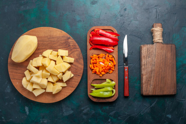 营养顶视图深蓝色背景上的新鲜土豆片和辣椒片水果膳食土豆
