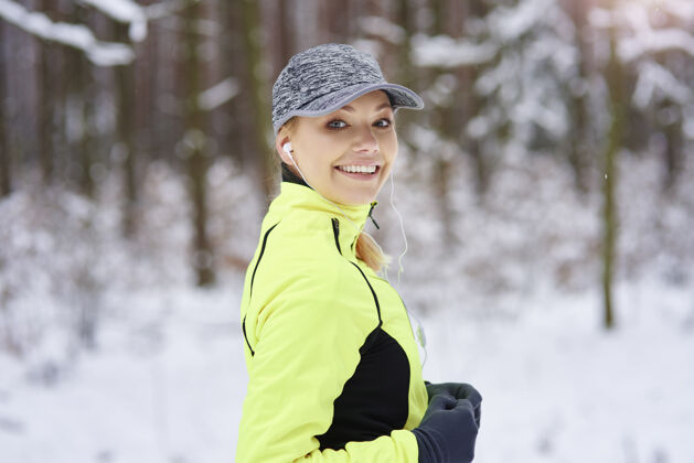 健康微笑的女人在冬天奔跑的画像肖像运动员音乐