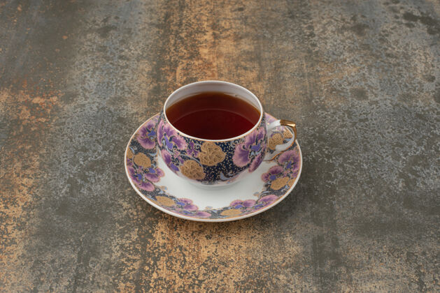 美味在大理石墙上放一杯热茶饮料杯子热的
