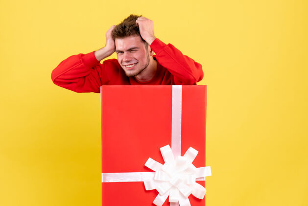 礼物正面图年轻男性站在礼品盒内雪丝带节日