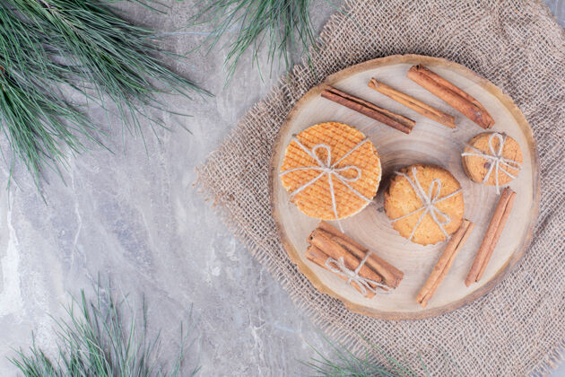 库存荷兰华夫饼和饼干放在木板上 周围放着肉桂棒美味顶部视图饼干