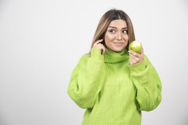 膳食穿着绿色t恤的年轻女子手里拿着一个苹果保持苹果年轻