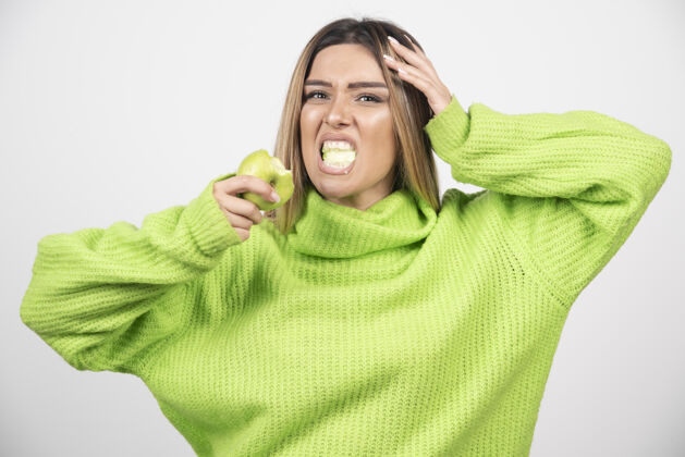 维生素穿着绿色t恤的年轻女子正在吃苹果苹果营养肖像