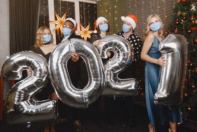 晚上圣诞老人装饰中的人们冠状病毒概念新年集体庆祝活动2021年带气球的人们豪华美国年