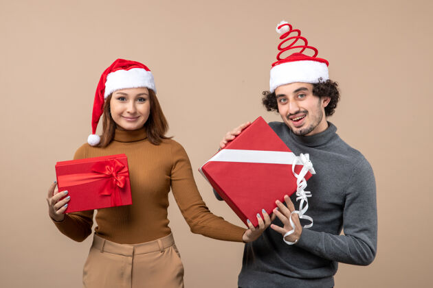 帽子新年气氛喜庆的概念与凉爽可爱的夫妇穿着灰色的红色圣诞老人帽子节日帽子服装