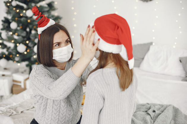 十二月为圣诞节做准备的人冠状病毒主题妈妈和女儿玩穿着灰色毛衣的孩子Covid19毛衣人