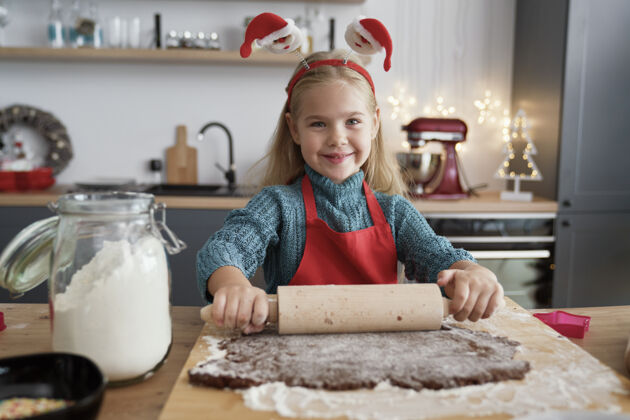 手工制作滚动姜饼面团的女孩画像甜食食物和饮料烘焙