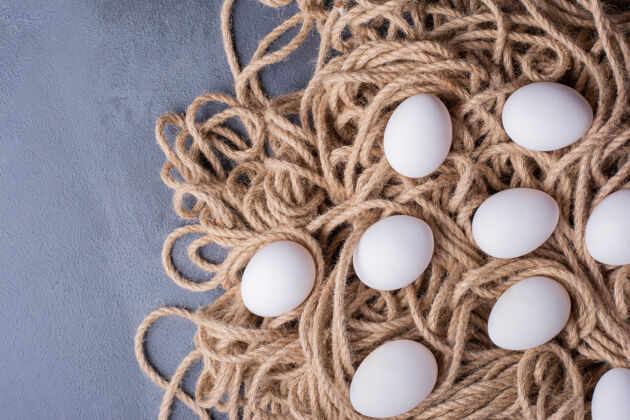 质量白色的鸡蛋在一堆粗线上传统顶部顶部视图