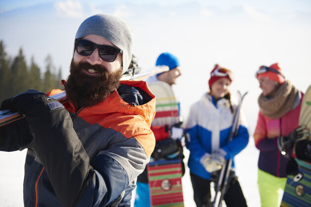 朋友带滑雪用具的大胡子男人度假情侣滑雪护目镜