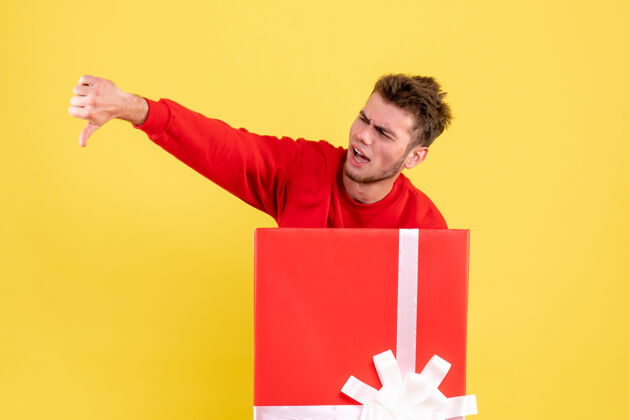 人正面图穿红衬衫的年轻男子坐在礼品盒内年里面成人