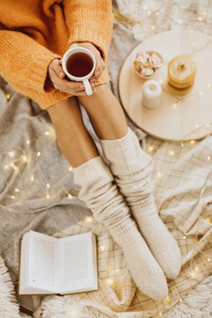 家高角度的女人用一杯茶享受寒假季节性温暖潮湿
