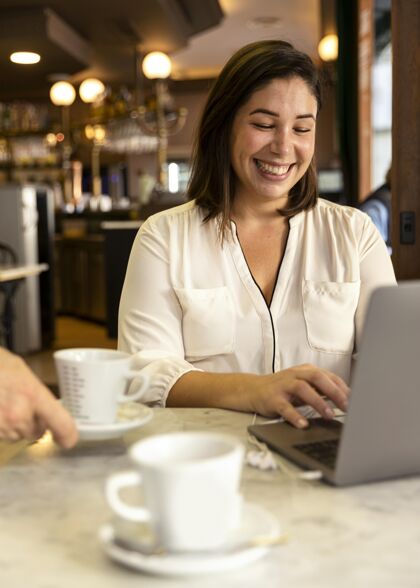 生活方式漂亮的年轻人在用她的笔记本电脑女孩商店咖啡店