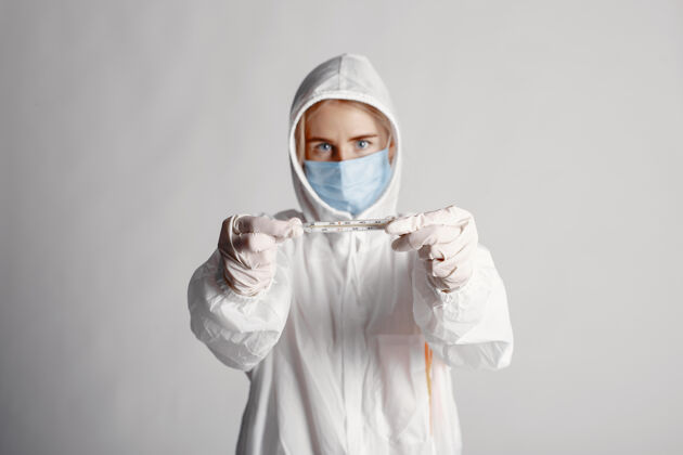 医学戴着医用面罩的医生冠状病毒主题白色背景下隔离穿防护服的女人实验室制服护理