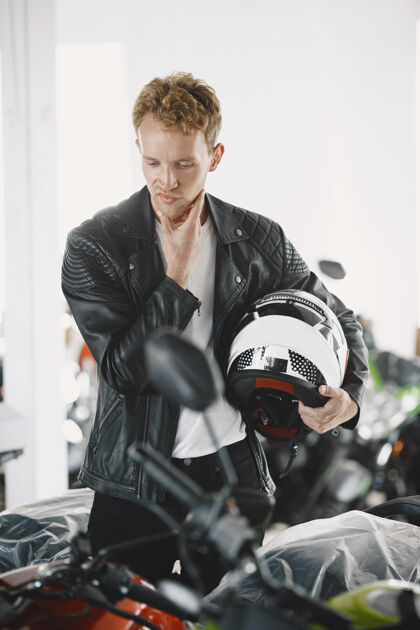 摩托车手一个男人在摩托店里选了摩托车一个穿黑色夹克的家伙交易男人检查