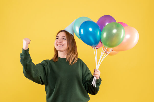 年轻正面图是一位年轻的女士 手里拿着五颜六色的气球乐趣聚会空气