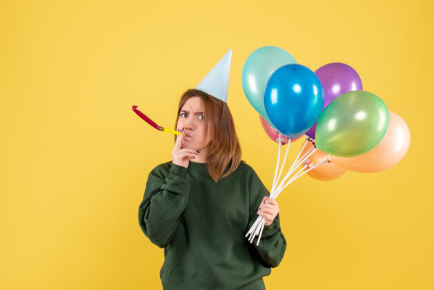 吹正面图是一位年轻的女士 手里拿着五颜六色的气球情感生日女人
