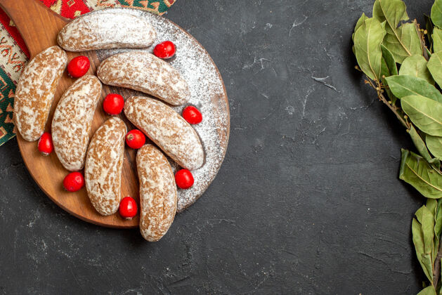 约束近距离观看美味饼干在棕色砧板上与红康奈尔浆果黑暗关闭美食圣诞节