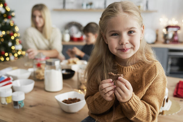 孩子坐在桌子上吃自制饼干的可爱女孩人手工制作降临