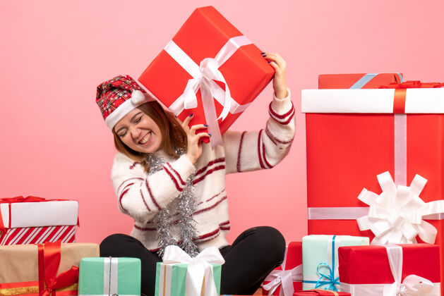 购物正面图年轻女性围坐在圣诞礼物旁边坐着颜色礼物