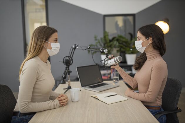 新闻戴着医用口罩的妇女在广播中一起广播的侧视图公告医疗面具医疗