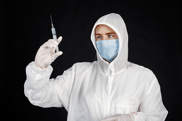 医生戴着医用面罩的医生冠状病毒隔离在黑墙上穿着防护服的女人肖像手套病人
