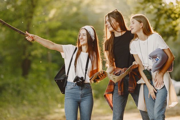 微笑冒险 旅游 远足和人的概念三个女孩在森林里女性团队女朋友