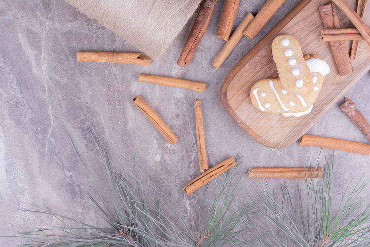 美味姜饼饼干和肉桂棒在长木板上咖啡馆扁平奶油