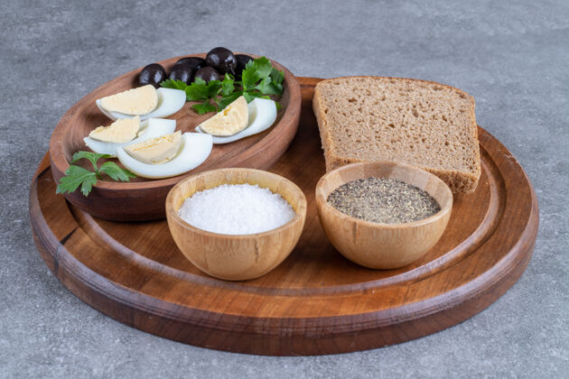 盐一块木板 上面放着煮熟的鸡蛋和一片面包高质量的照片食物美味橄榄