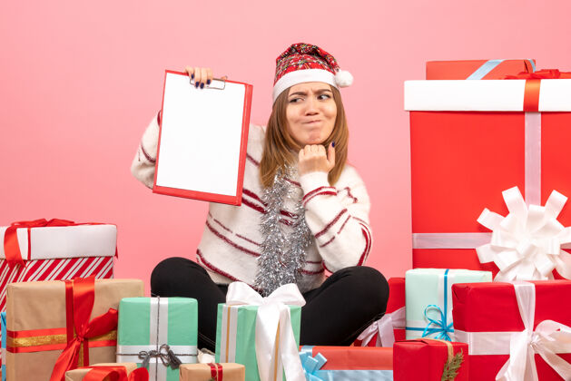 颜色前视图年轻女性围坐在圣诞节礼物与文件说明成人情感粉色