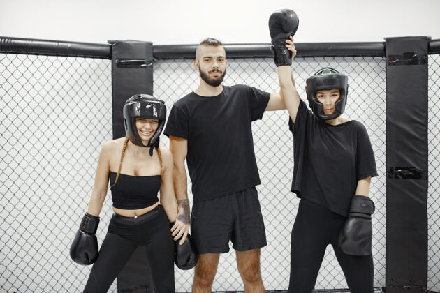 拳击女子拳击裁判宣布冠军穿黑色运动服的女士女教练健身房身体练习