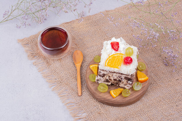 面粉一块正方形的水果蛋糕和一杯茶小吃木制咖啡馆