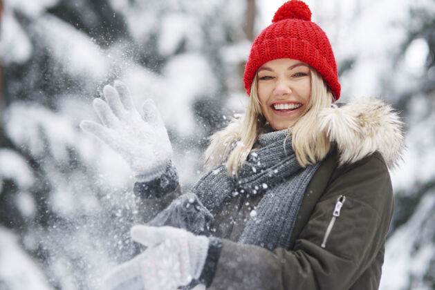 成人快乐的女人在冬天玩得开心冷针织帽子山